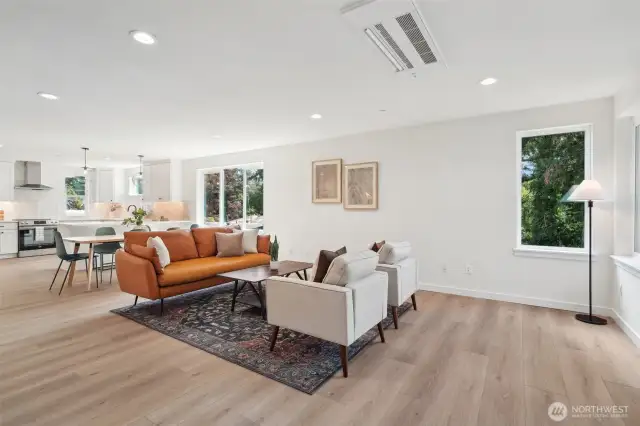 Photos of staged unit, 20313A. Floor plans are identical. Expansive living room with LVP flooring and ceiling mounted high efficiency heating and cooling mini-split system