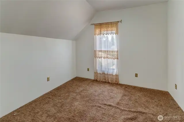Charming upstairs bedroom with cozy sloped ceilings and soft natural light—ready for a restful retreat or creative refresh