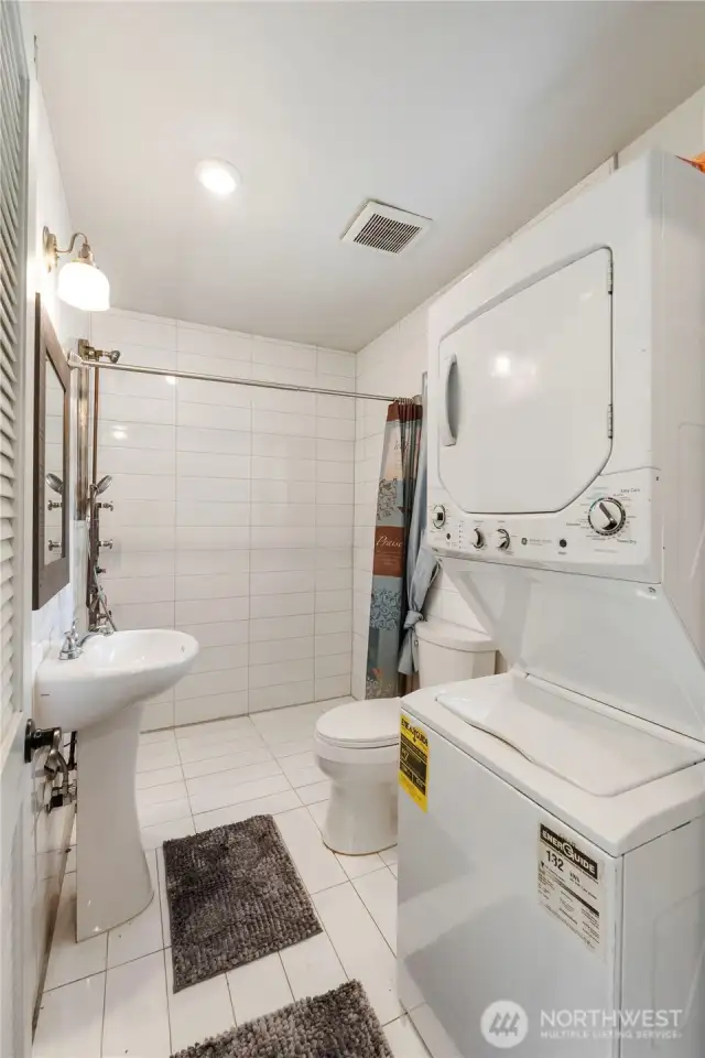 Fully tiled guest bath offers shower and laundry amenities.