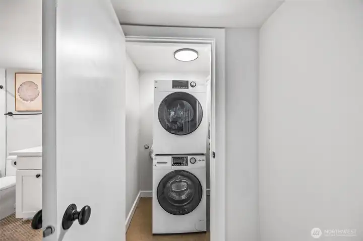 Stackable washer/dryer on lower floor off media/recreation living room.