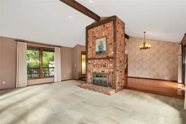 One step down to the spacious living room. Picture on fireplace stays with the home.