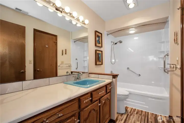 Hall bathroom with new counter, flooring and bathtub/shower.
