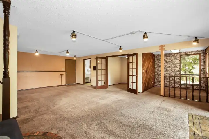 Downstairs you will find the family room, the room with the wood wall was used as an office, the one next to it with french doors was a storage/craft room. The laundry room is the last room and the door leads to the garage.
