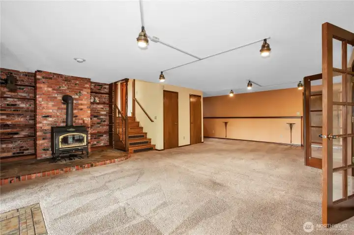 View of family room from the office, has wood burning fireplace, first door is a closet, the second door on the right is a closet with the  laundry shoot.