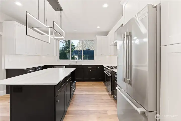 Huge kitchen, lots of cabinets and countertop space, big kitchen island with eat-in space, premium finishes, custom light fixtures, quartz counters.