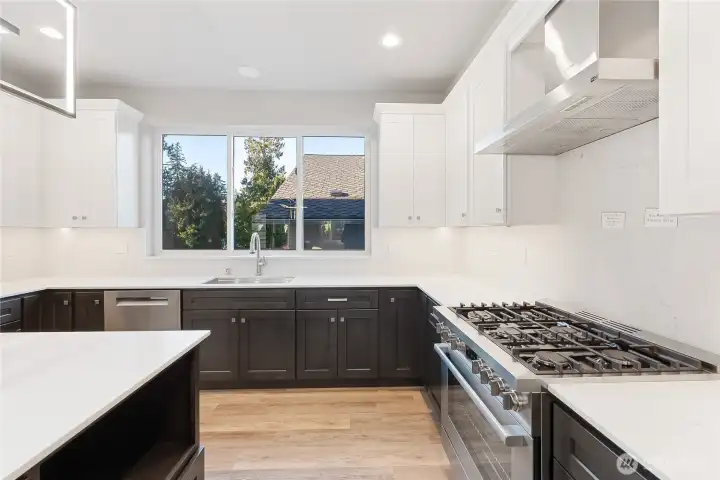 Custom kitchen sink comes complete with a cutting board, and strainers. Six-burner natural gas Bosh stove. Solid slab quartz backsplash! Bosh stainless steel appliance package!