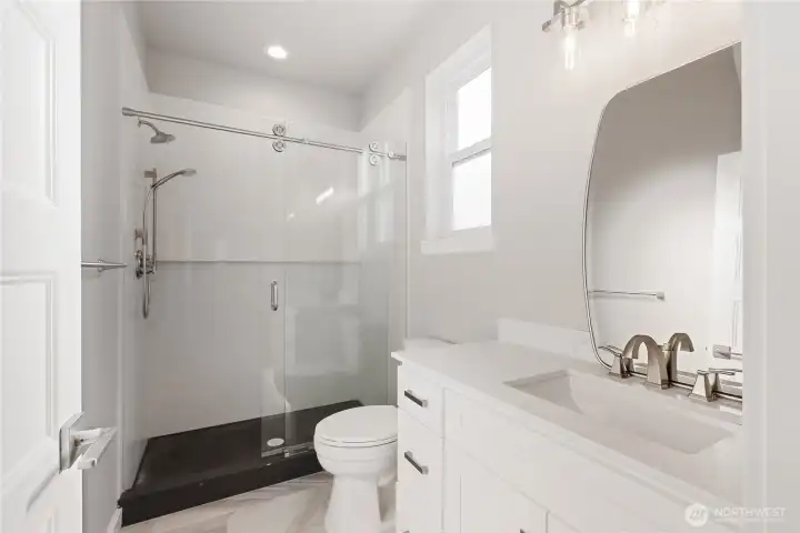 The downstairs primary bathroom features under cabinet lighting, solid one piece quartz slab shower, with a solid one piece quartz pan! This is a very rare feature, making the shower a seamless beauty that is easy to clean and maintain! Tile floor throughout.