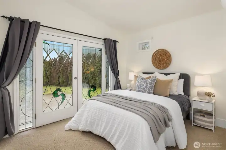 Home #2: Bedroom with custom stained glass french doors and sidelight windows. This bedroom also has a walk-in closet.