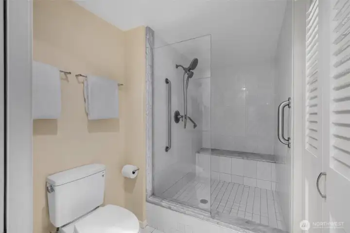 The walk-in bath is huge and has a built-in bench seating and a Toto toilet.