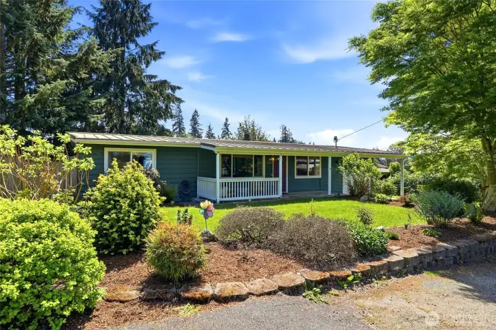 Inviting front porch and beautifully maintained yard create a warm first impression.