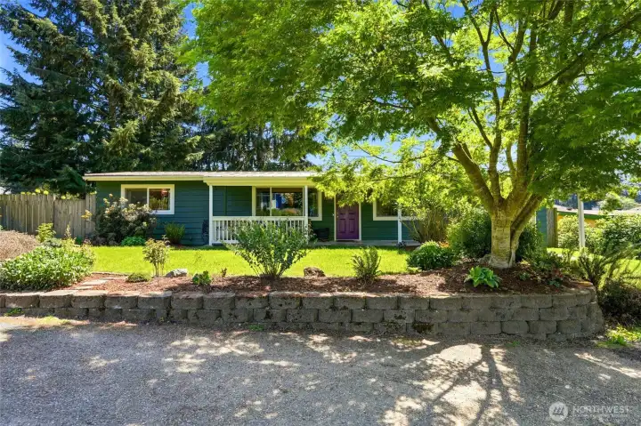 Charming curb appeal with lush lawn, established landscaping, and a peaceful residential setting.