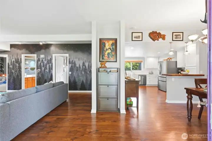 Step inside to an open and inviting layout with warm flooring and seamless flow between living, dining, and kitchen spaces.