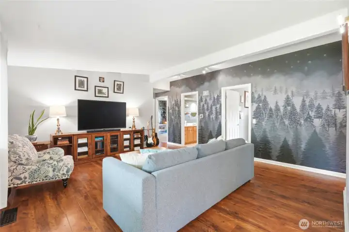 Spacious living room highlighted by a stunning hand painted mural that adds character and a unique focal point.