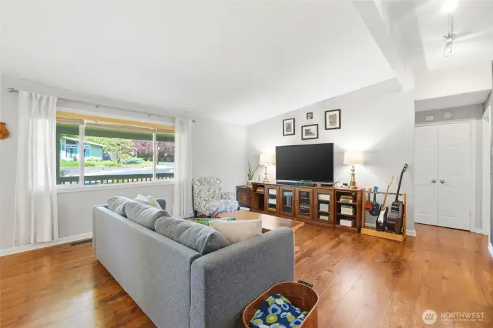 Bright and comfortable living area with large windows bringing in natural light and showcasing the open layout.