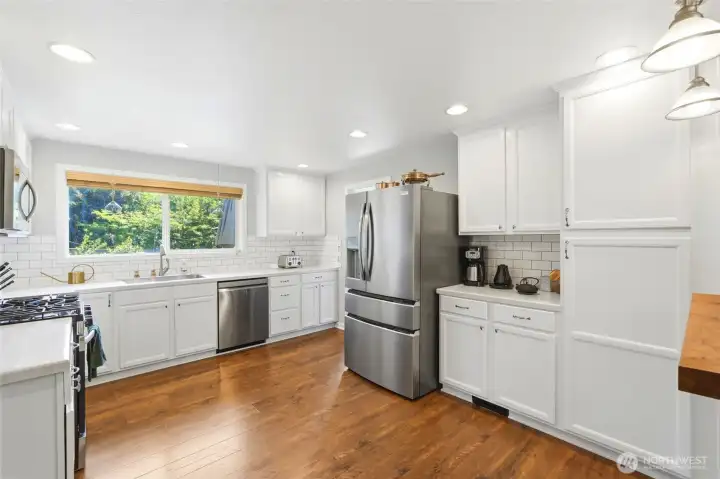 Bright, updated kitchen featuring white cabinetry, stainless steel appliances, and abundant storage.