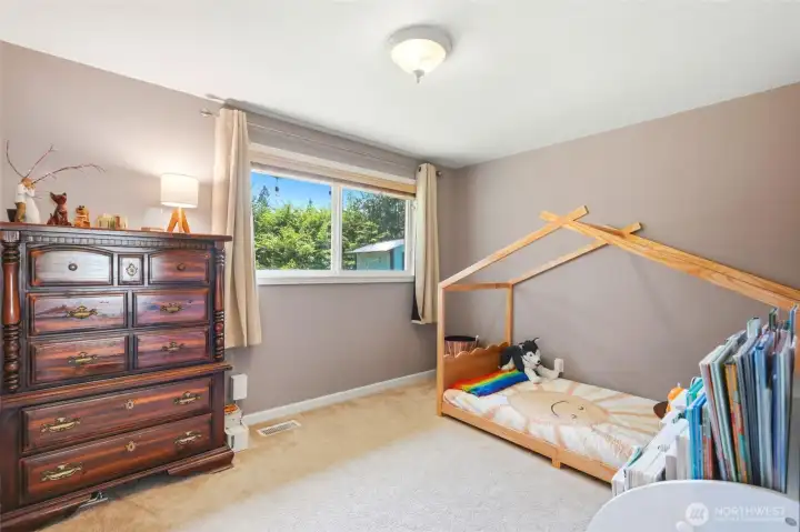 Bright secondary bedroom with generous window and comfortable layout, perfect for guests or everyday living.