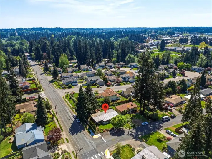 Aerial perspective highlighting proximity to nearby amenities, tree-lined streets, and surrounding community.