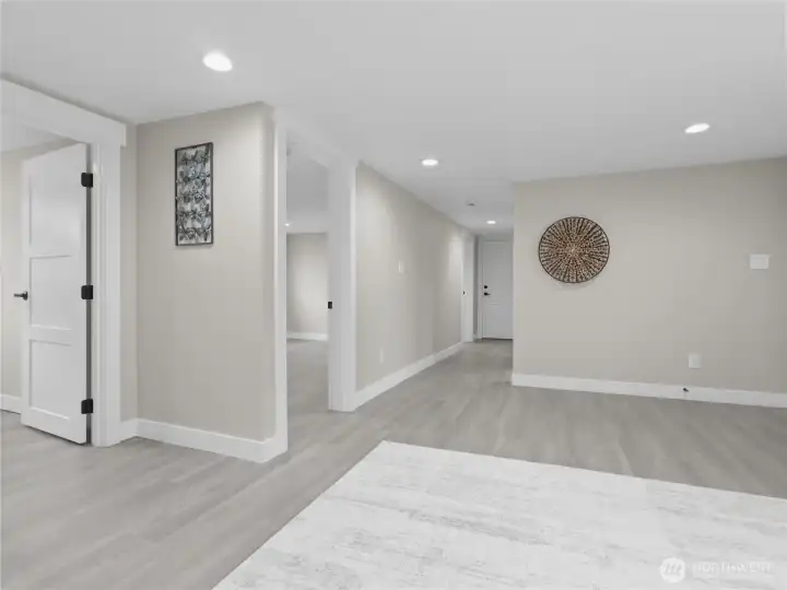 Lower level view of hall to bedrooms 3 & 4, garage and office space