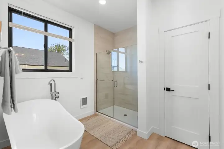 Primary Bathroom soaking tub and walk in tiled shower with double rain shower heads.