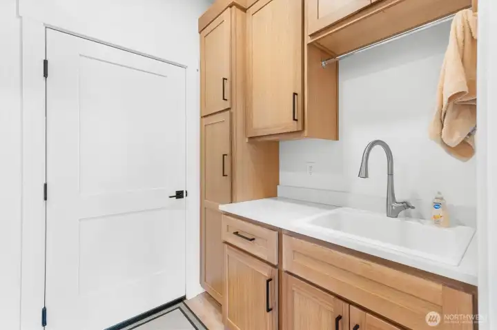 Laundry room with sink and cabinets.