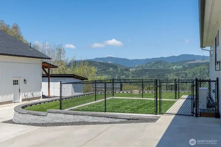 Fenced Dog run.  Doorway in the garage with a doggie door leads into the dog run.