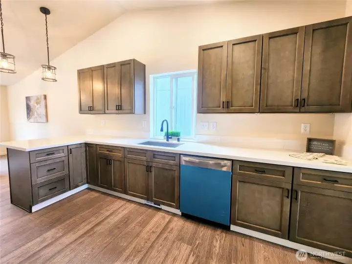 Deep single basin sink with gorgeous quartz counters.  Astounding amount of cabinetry and storage in this kitchen!
