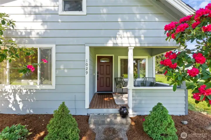 Cute as  a button covered porch faces east