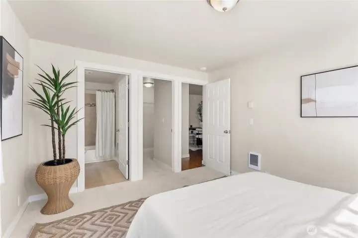 Primary bedroom with ensuite full bath, walk-in closet, and entrance to living room