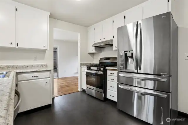Updated kitchen with stainless appliances, an eating area and a gas range.