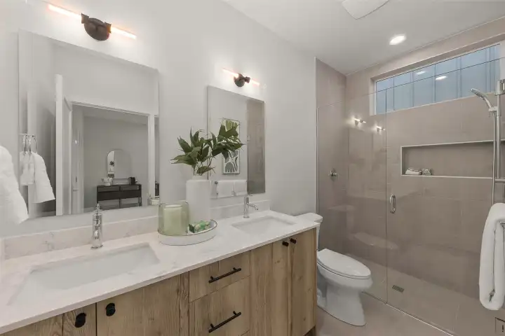 Sleek primary bathroom featuring a modern vanity, deep drawer storage, and soft finishes.