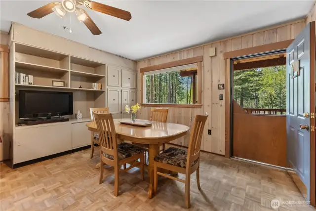 Charming dining room with built-in cabinetry, stunning river views, and classic knotty pine paneling throughout—adding warmth and character to every gathering.