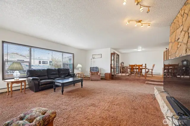 Main House: Spacious living room with wood-burning fireplace & wet bar with beautiful picture windows offering lots of natural light.