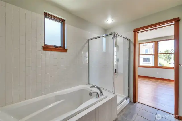Primary bath with privacy pocket door, soaking tub and separate shower with subway tile - classic and clean look.