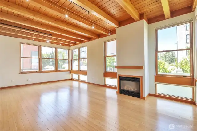 Main living room / dining area on 2nd level featuring a gas fireplace, bamboo flooring, exposed wood beam ceilings with attractive, modern track lighting.  Indoor sprinkler system throughout the unit.