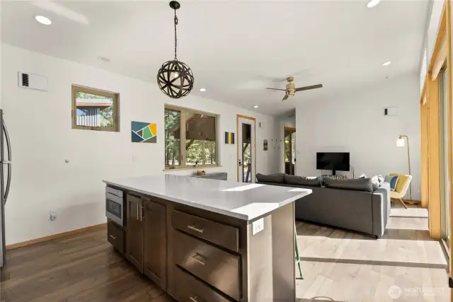 Entertain with ease — Island bar, stainless hood, and custom pendant lighting add warmth and function.
