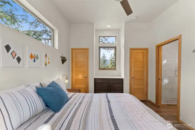 Primary bedroom with serene forest view – Wake up to trees, trails, and mountain light from your cozy retreat.