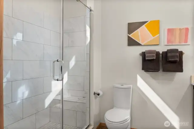 Primary Bathroom – Sleek and modern with a tiled walk-in shower, streamlined fixtures, and bright natural light—style and comfort in the heart of the home.