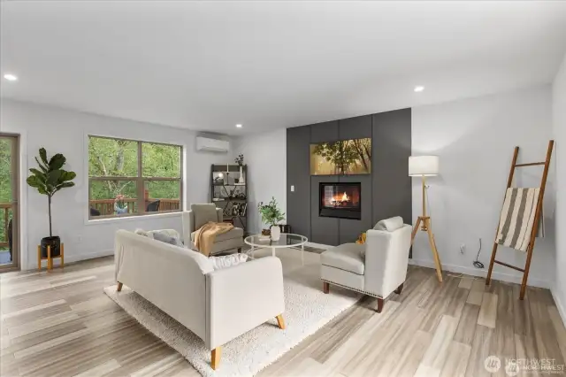 Windows flood the living area with light, showcasing the surrounding trees and forest.