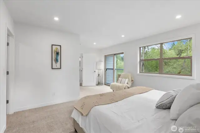 With its view of the trees, the primary bedroom is a tranquil, rejuvenating space.