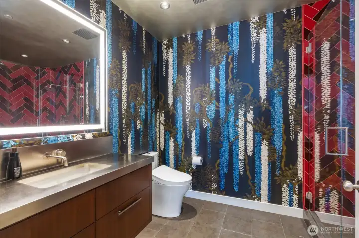 Crestola marble flooring. Sonoma Stellar Series herringbone pattern shower tile. Custom mirror. Toto Aquia washlet toilet. Stainless steel countertop.