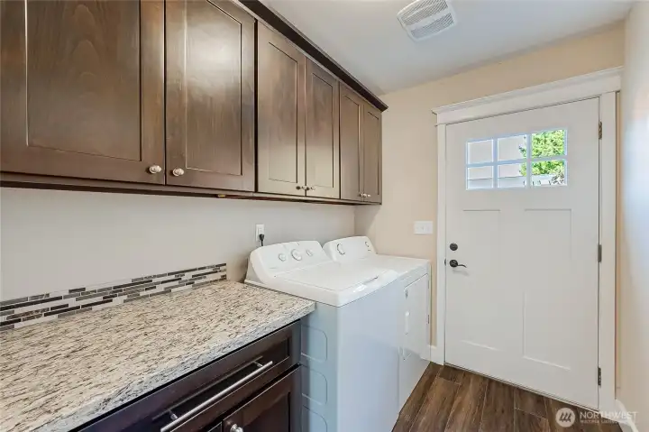 Laundry room with cabinet storage and granite counter. Washer and dryer stay!
