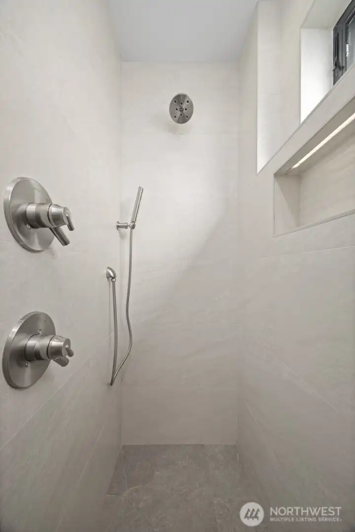 The stone tiled shower is an absolute work of art.