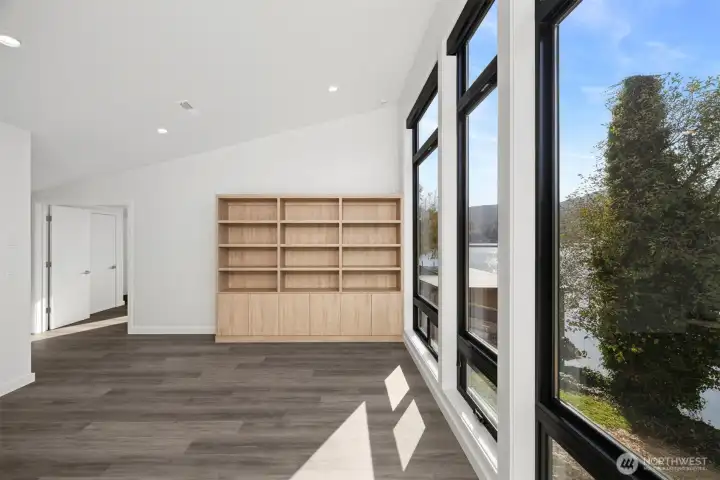 The other room upstairs is ideal for a family or rec room and has beautiful built-ins and floor-to-ceiling windows that look out to Big Lake.