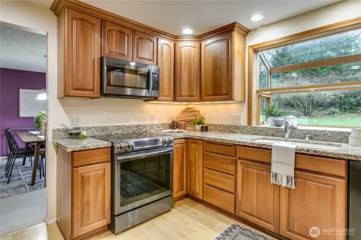 Chef's kitchen w/ cherry cabinets and window box overlooking backyard