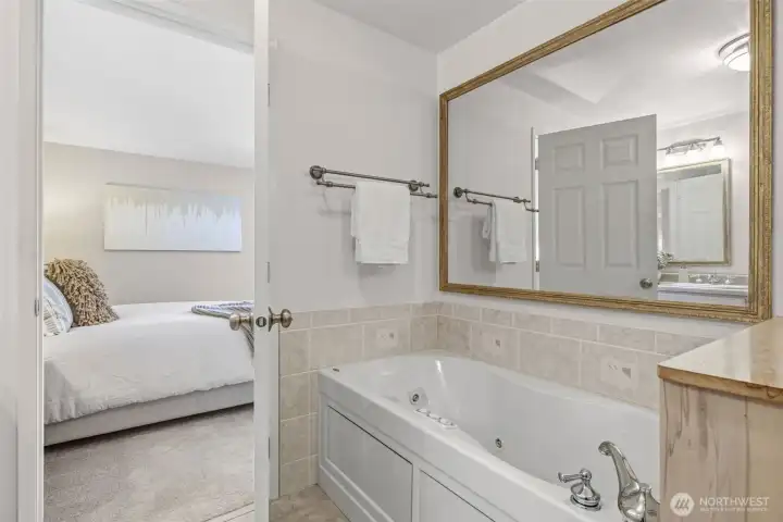 Serene primary suite with full bath en suite including a jetted tub.