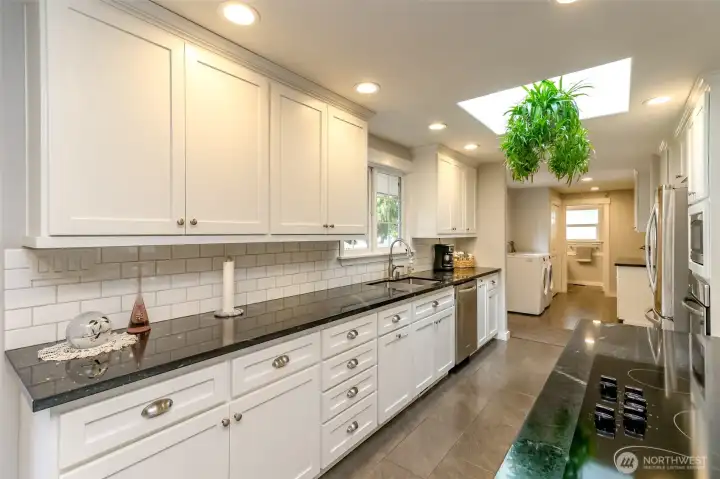 Built for daily life this bright kitchen opens to a generously appointed laundry room with additional storage and counter space plus a nearby three-quarter bath