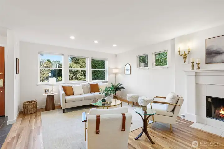 Living Room - Large extended room with plenty of light from windows all around, accented by a wood fireplace.
