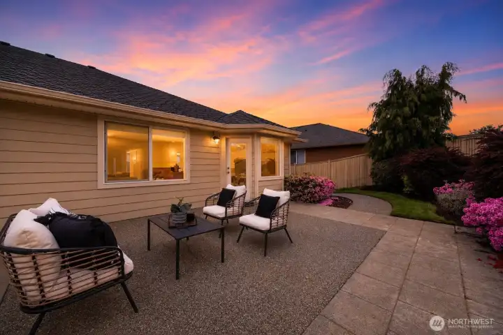 Spacious backyard with concrete walkway along North side of home
