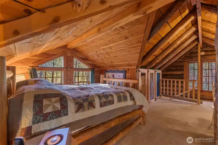 The upstairs bedroom is cozy yet pulls in natural light from all sides.