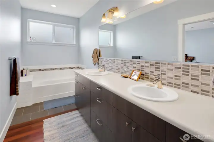 The primary suite continues into a thoughtfully designed bathroom complete with a soaking tub, double vanity, and large walk-in tiled shower.